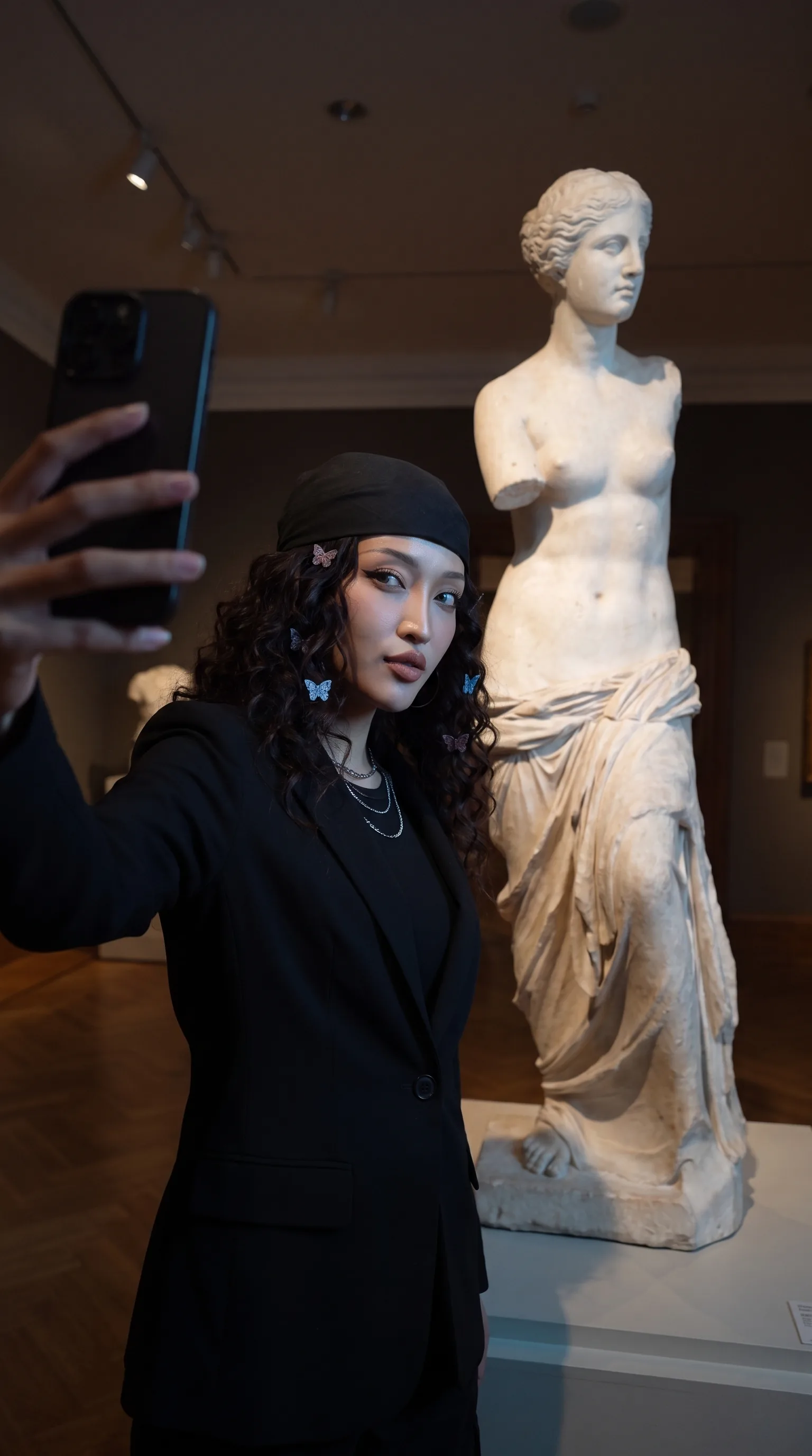 Late-night museum selfie beside a marble statue (synthetic avatar)