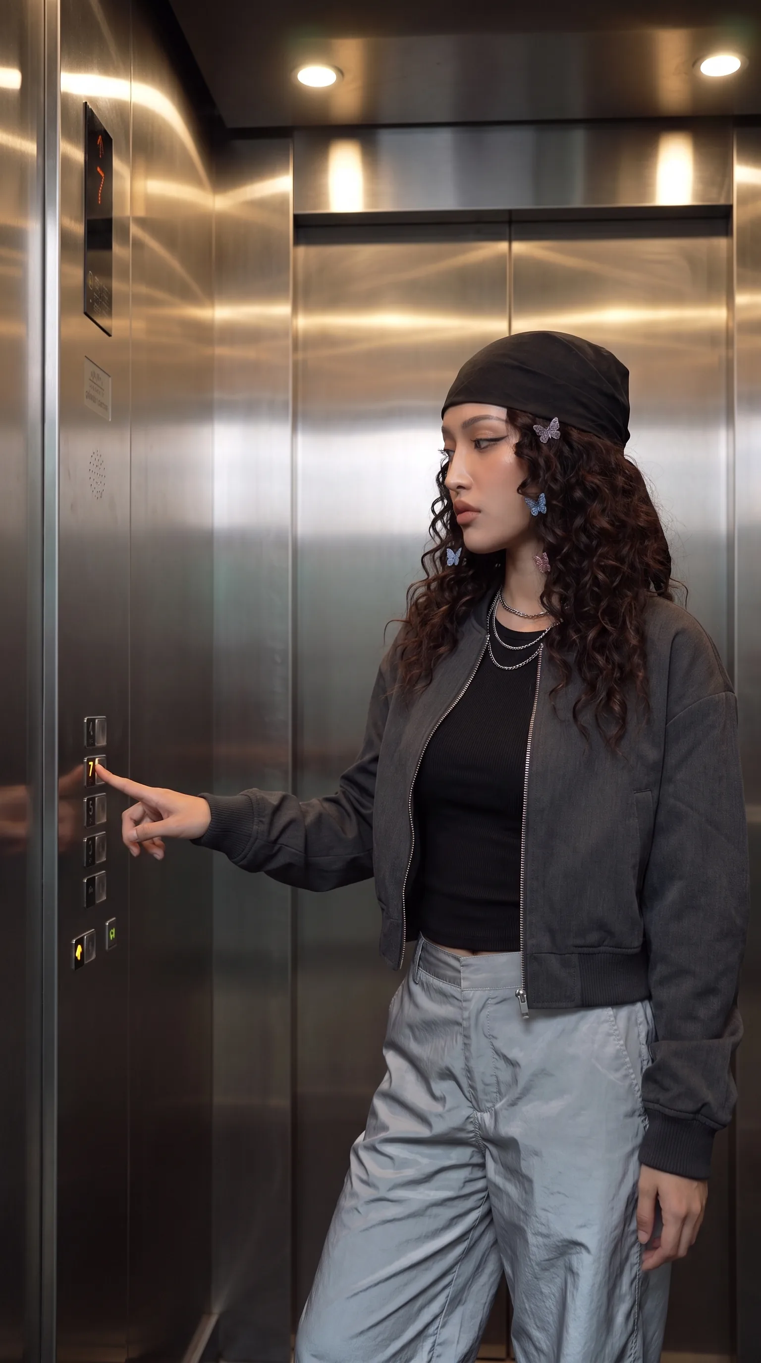 Synthetic avatar in a hotel elevator about to press a button