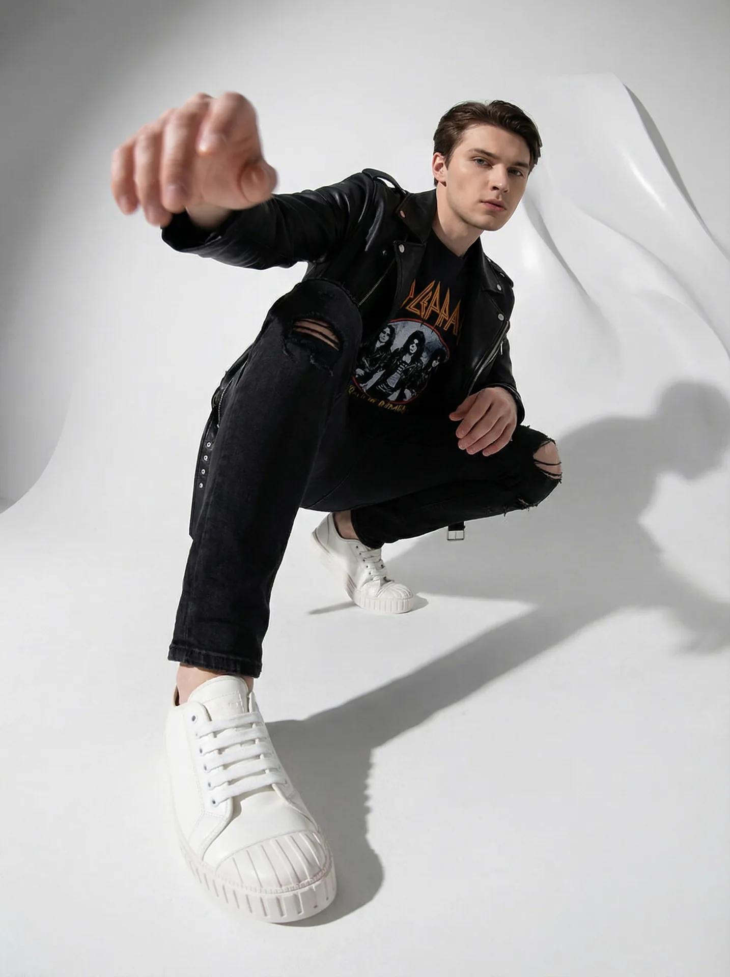Fashion editorial in a black leather jacket, low angle with a wide lens